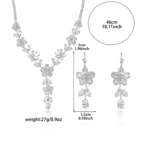 Ensemble collier et boucles d'oreilles en zircon émeraude avec motifs floraux sur fond blanc