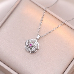 Détail macro du pendentif fleur argenté avec pierre rose et pavage en oxydes de zirconium