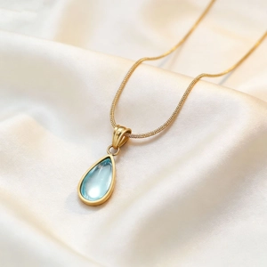 Elegant gold snake chain necklace featuring a vintage light blue teardrop gemstone pendant