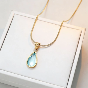 Elegant gold snake chain necklace featuring a blue water drop gemstone pendant