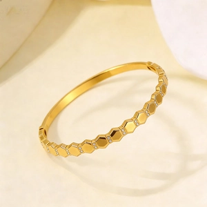 Polished gold honeycomb steel bangle with delicate white zircon stones and hinge closure