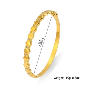 Gold stainless steel bangle with hexagonal honeycomb texture and crystal inlay