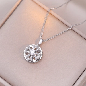 Silver-tone rotating bauhinia flower pendant necklace with white zircons in a jewelry box