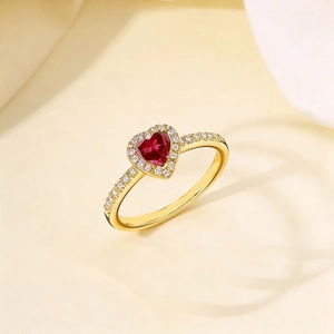 Primer plano de un anillo de rubí con forma de corazón y halo de diamantes en oro