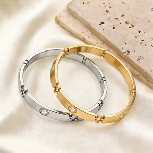 Titanium steel bangles in gold and silver with screw motif and clover diamond accents