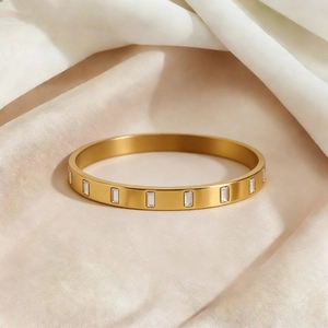 Bracelet jonc en acier titane plaqué or 18k avec zircons rectangulaires sur tissu satin