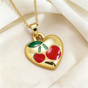 Elegant gold titanium heart necklace featuring a red cherry enamel design on silk