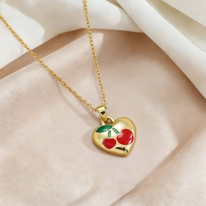 Golden titanium steel necklace with heart cherry pendant on smooth silk background