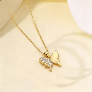 Macro shot of gold butterfly pendant with sparkling zircons and polished finish