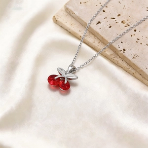 Titanium steel necklace featuring a vibrant red cherry pendant with silver leaves