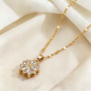 Collier en acier titane doré avec pendentif fleur en zircon scintillant sur tissu élégant