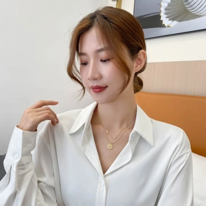 Double layer gold titanium necklace with cross and round disc pendants on female model