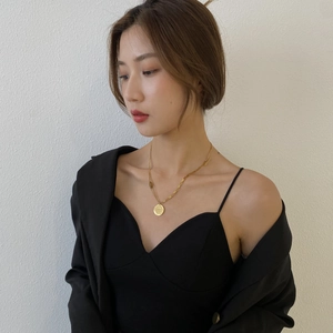 Détail du collier double rang en titane doré avec un pendentif pièce ronde gravé