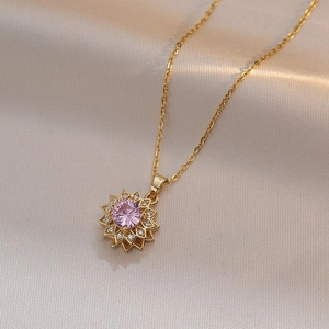 Halskette aus Titanstahl in Gold mit rotierendem Sonnenblumenanhänger und rosa Zirkon