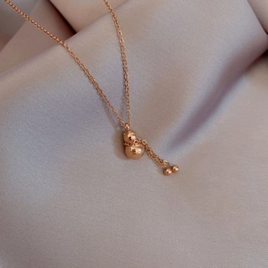 Detailed macro view of a rose gold gourd pendant with tassels and Fu character engraving