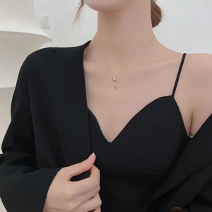 Minimalist 18K gold gourd pendant necklace with tassel on model for a chic look