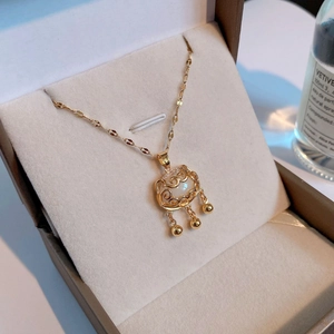 Détail du collier cadenas Ruyi doré avec pierre translucide et glands de perles fines