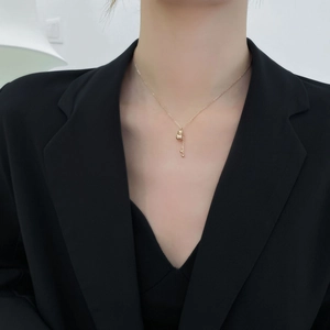 Titanium steel 18K gold gourd necklace with tassel pendant on model in black blazer