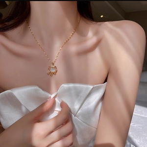 Détail d'un collier pendentif chat doré avec pierre oeil de chat sur un mannequin