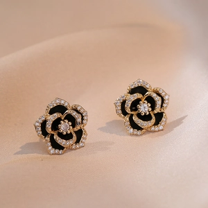 Elegant camellia stud earrings with black enamel and zircons on champagne silk