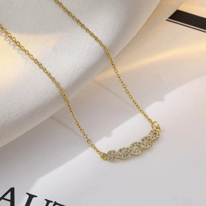 Elegante collar de acero de titanio dorado con un colgante en forma de 8 engastado con circonitas