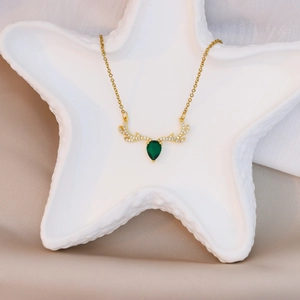 Detailed view of titanium deer antler necklace with green teardrop zircon on silk