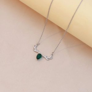 Macro view of elk antler pendant with green teardrop zircon on a silver chain