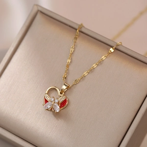 Collar de corazón dorado con lazo rojo y colgante de mariposa de circón para mujer
