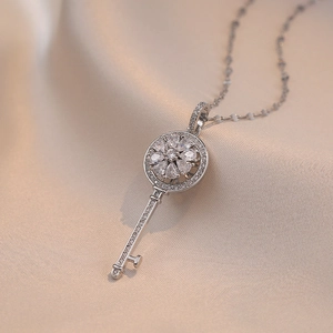 Collier avec pendentif clé en zircon rotatif en acier inoxydable sur fond de soie douce