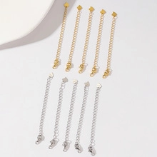 Macro detail of 10-piece gold and silver extension chains with heart charms and lobster clasps