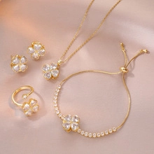 Detail of clover jewelry set with gold finish and heart-shaped crystals in a macro view