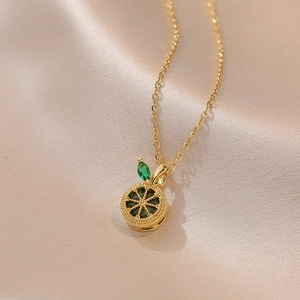 Collier tranche de citron doré avec zircone verte sur tissu de soie champagne chic