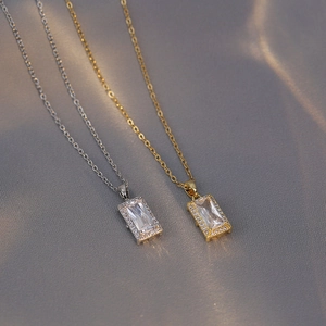 Vue macro d'un pendentif en zircon taille émeraude avec halo sur une chaîne fine