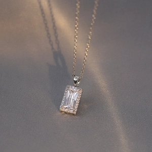 Détail du pendentif avec zircon taille émeraude et entourage de diamants sur chaîne