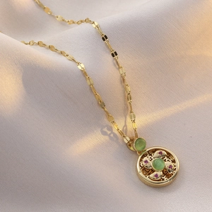 Elegant gold necklace with cat eye stone windmill pendant on soft silk background