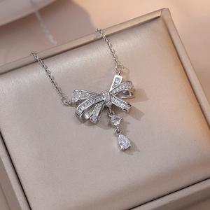 Détail du collier pendentif nœud avec goutte en zircone dans son écrin à bijoux