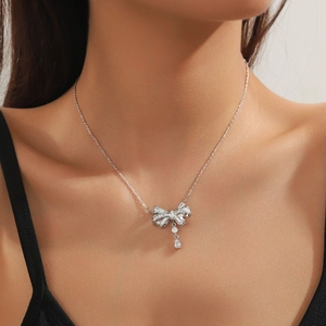 Collier élégant en argent avec nœud et pendentif goutte sur la clavicule du mannequin