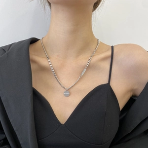 Collier minimaliste en acier titane avec pendentif Good Luck sur cou de femme