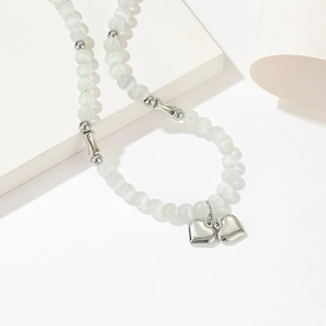Collana minimalista con perline occhio di gatto e due ciondoli a cuore in argento su blocco