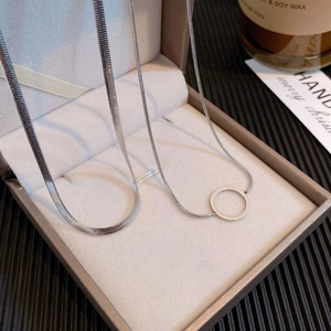 Silver snake chain and hollow pendant necklace displayed in a luxury gray jewelry box