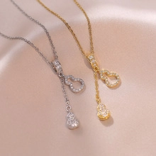 Detailed close-up of gold and silver gourd pendants with micro-pave crystals on silk