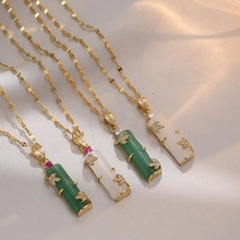 Detail of bamboo-shaped pendants with green jade-style stones and gold leaf accents