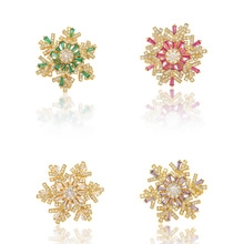 Close-up of four snowflake rings with emerald, rose, white, and purple zircon stones