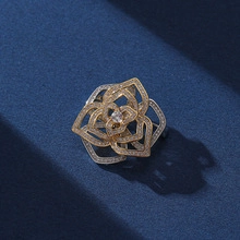 Detail of multi-layer hollow flower brooch with gold plating and sparkling zircons