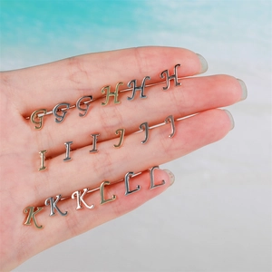 Close-up of 18K gold-plated letter stud earrings in gold, silver and rose gold