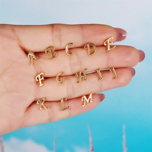 Detailed shot of polished 18K gold letter charms A to M for customizable jewelry