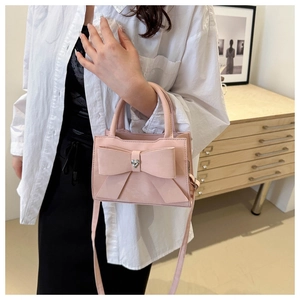 Détail d'un sac à main rose avec nœud et boucle en strass en forme de cœur pour femme