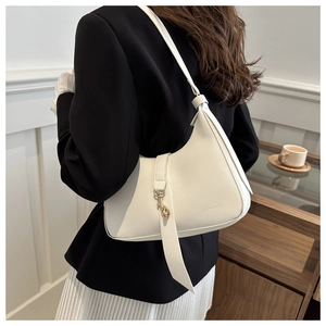 Chic white hobo shoulder bag with gold hardware worn by a model in a minimal setting