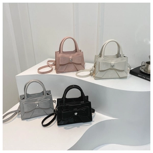 Sacs à main chic avec nœuds en rose, beige, gris et noir sur un présentoir minimaliste
