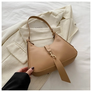 Detail view of khaki hobo shoulder bag with golden buckle on a white blazer background